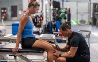 A therapist performing soft tissue therapy on a female patient.