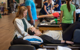 Natalie Black adjusting a patient's head and neck.