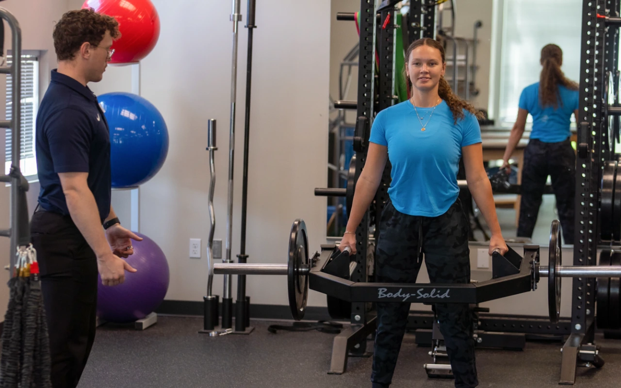 A young woman doing a deadlift.