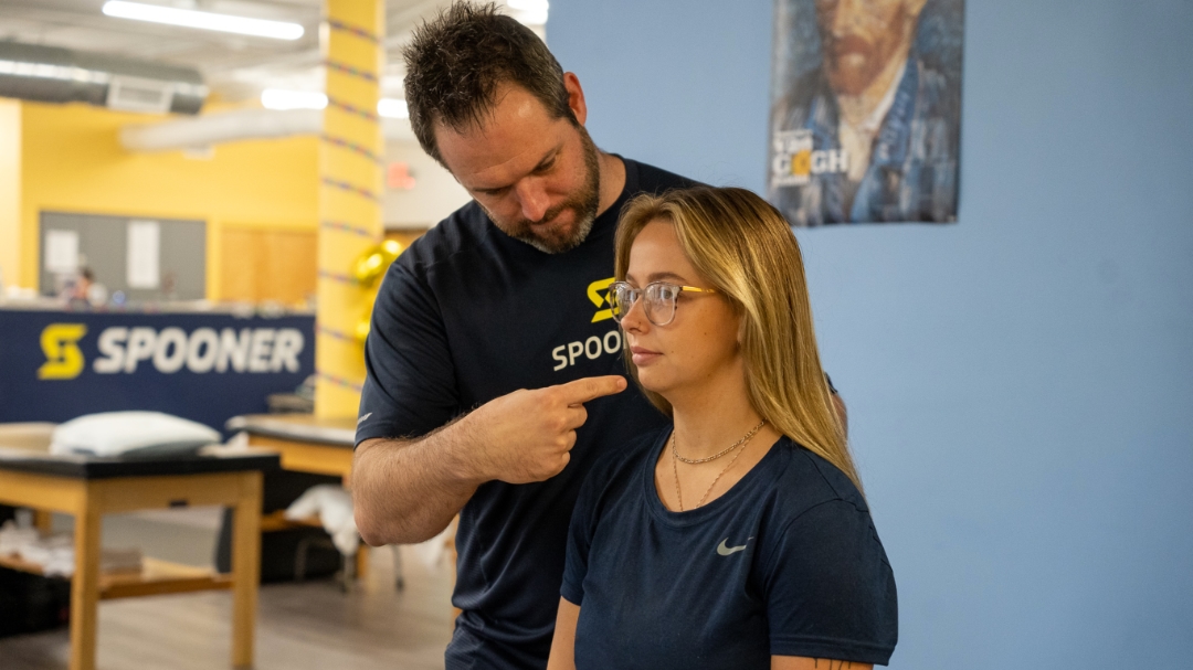 Paul Ryan pointing to patient's chin reminding them to keep the chin back instead of the head.