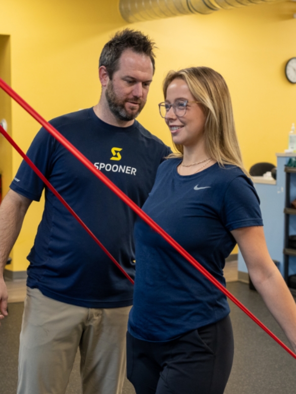 out-Spine Image 1 Image of a woman pulling on a tension band and pinching her shoulder blades together.