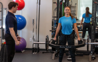 A young woman doing a deadlift.