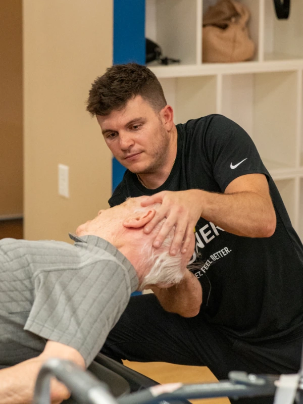 out-Vestibular Page Image 2 Image of an older man having his head and neck adjusted by a male physical therapist.