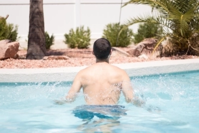 A man doing jumping jacks in a pool.