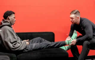 A physical therapist performing ankle manipulation on a basketball athlete.