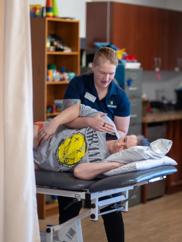 A hand therapist working on the shoulder of a patient.