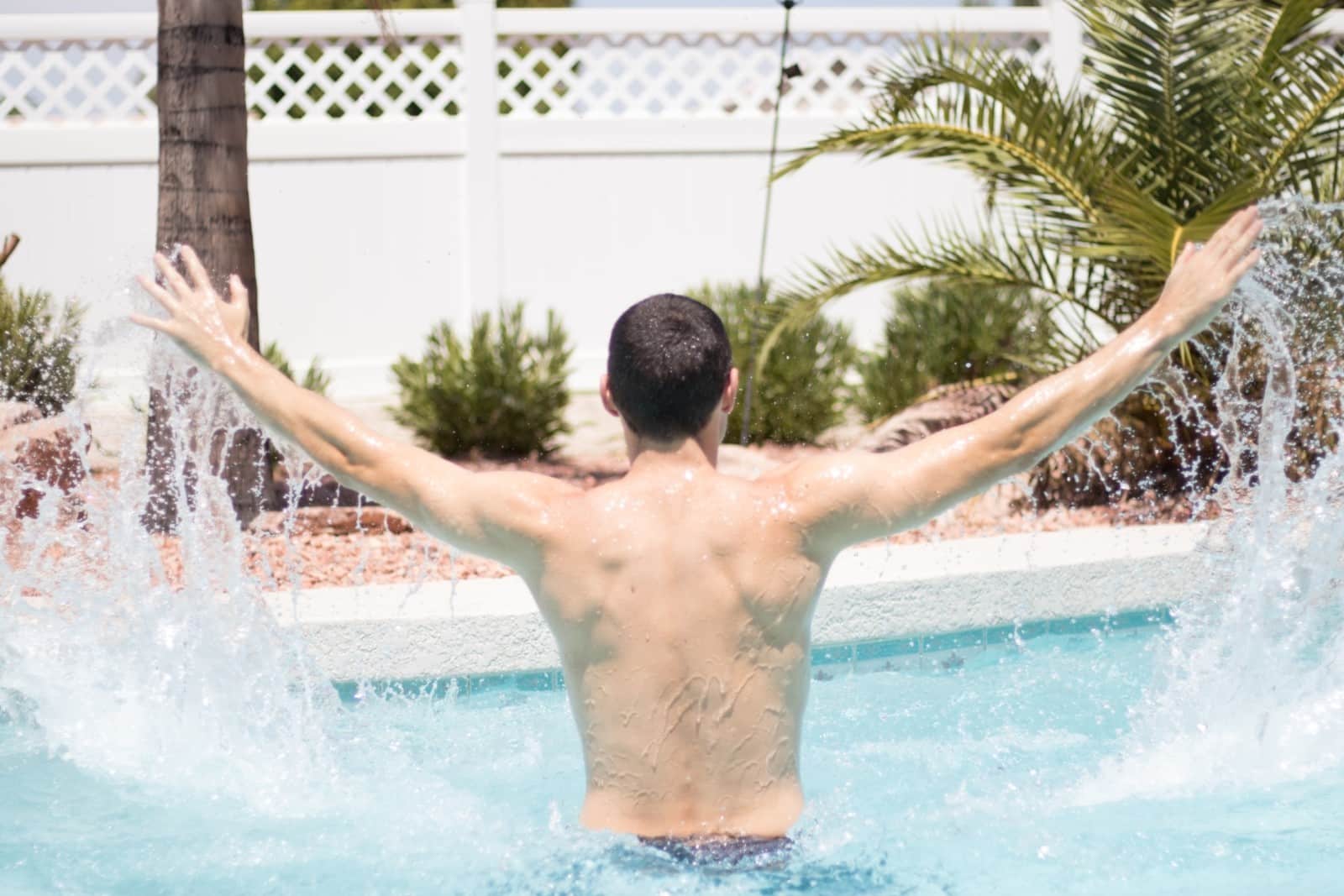 A man doing jumping jacks in a pool.