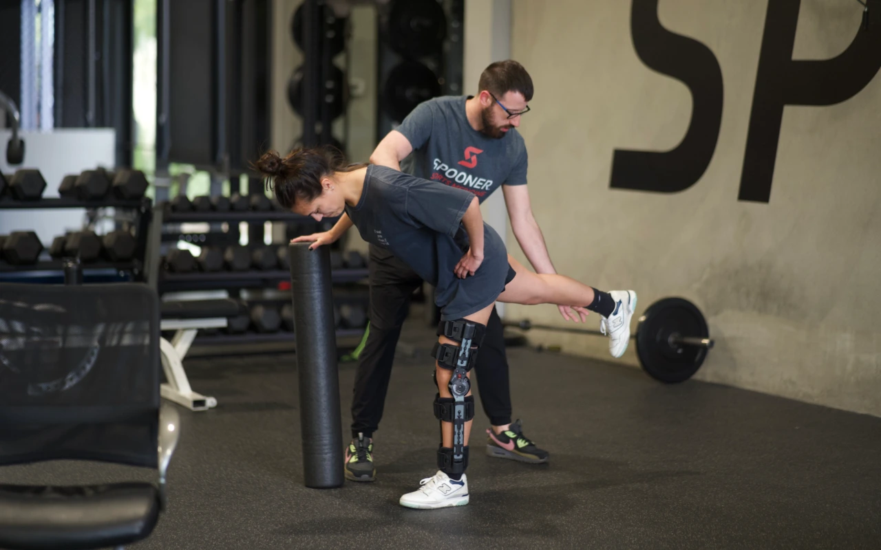 A physical therapist rehabilitating a female athlete after knee surgery.
