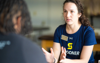 Samantha Kogler, OTR/L, OTD, CHT talking with a patient.