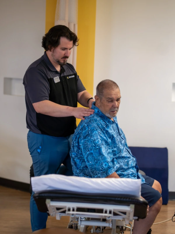 A therapist assessing a patient with spinal stenosis.