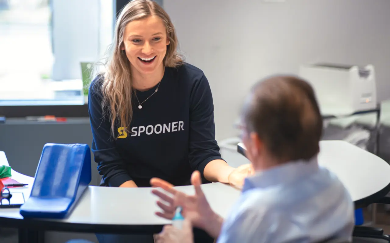 A hand therapist discussing the benefits of hand therapy treatment for trigger finger with a patient.