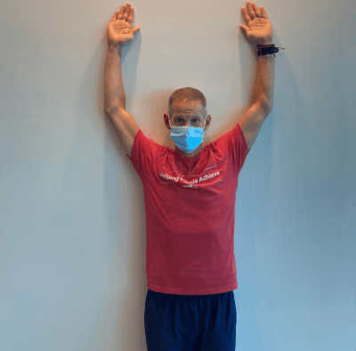 A man demonstrating wall angels step1.