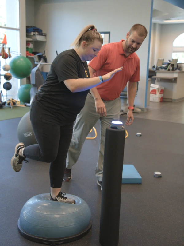 out-Vestibular Page Image 1 Image of a woman balancing on a bosu ball while she goes to hit a blazepod.