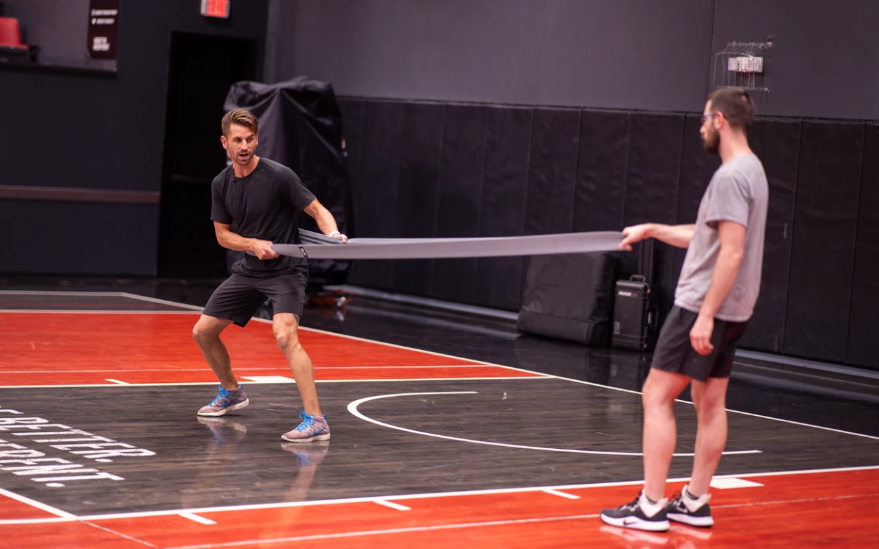 Adam Loiacono with an assistant doing a demonstration on a basketball court.