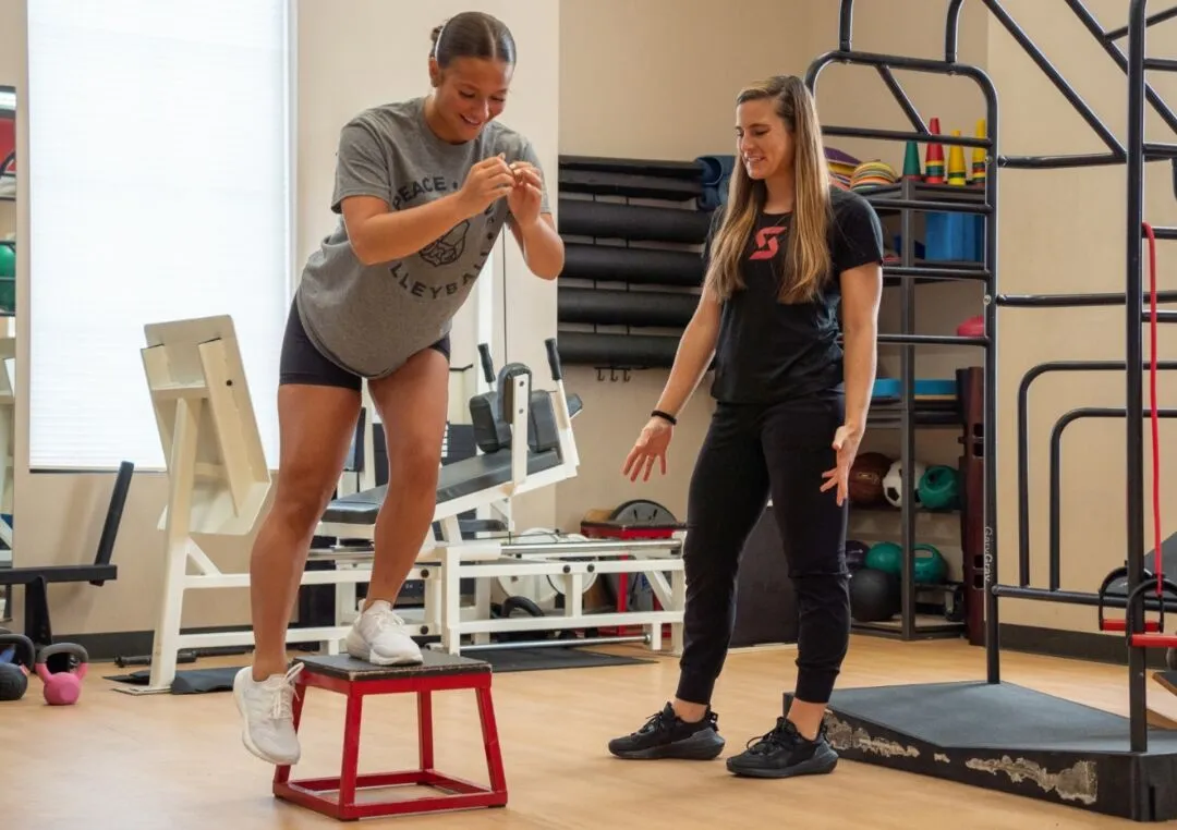 Feature image of a female athlete balancing on one foot on a blue balance pad.