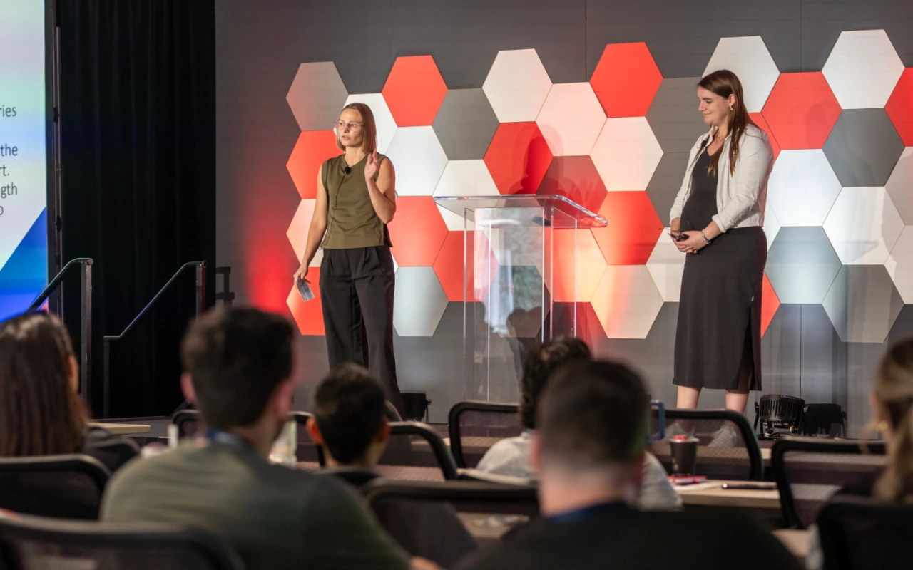 Alix and Molly speaking at the Huddle 2025.