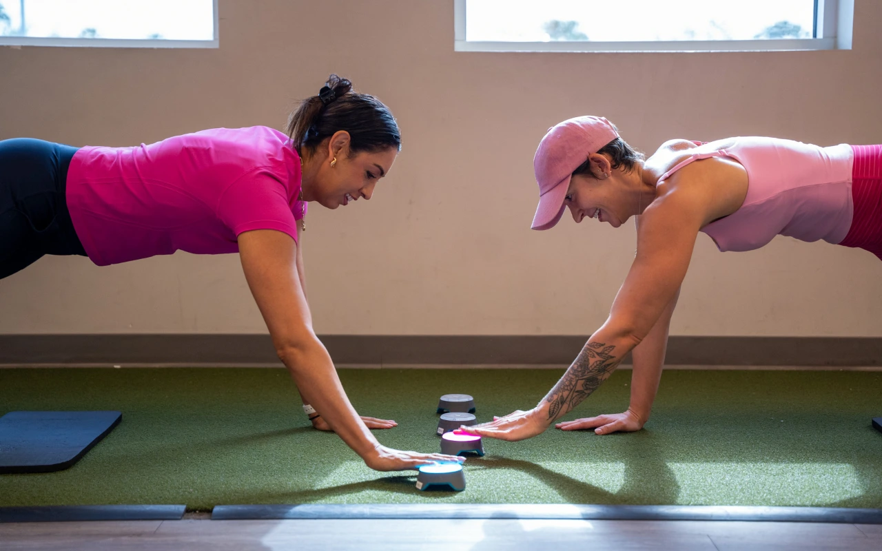 A breast health therapist working with a survivor one the floor with Blazepods.