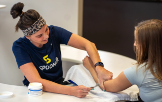 A hand therapist working on the forearm of a patient.