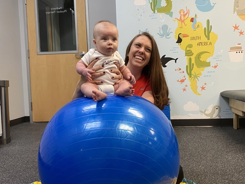 therapist with baby on ball
