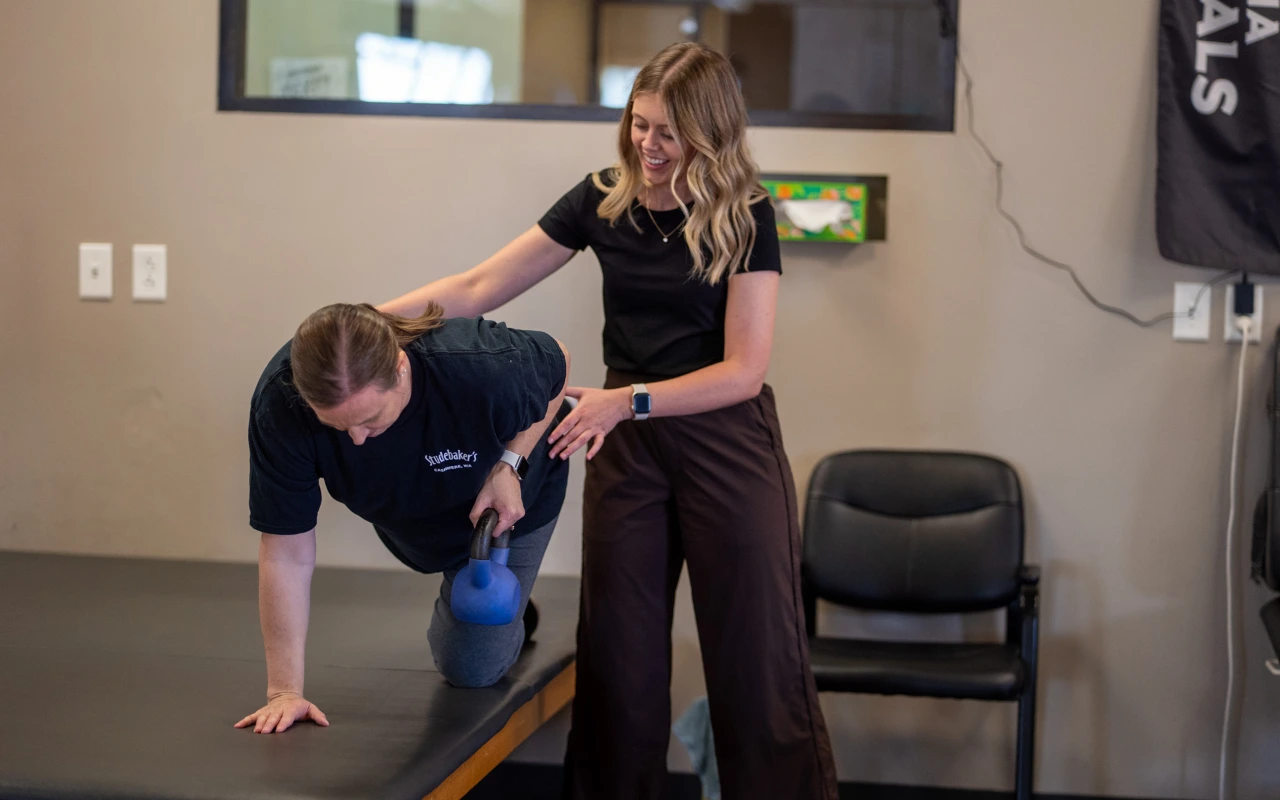 A physical therapist with a woman doing exercises.