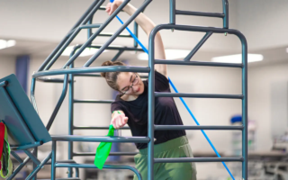 A teen stretching in a stretch cage to help improve her scoliosis.