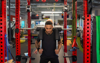 A man using a squat rack at Spooner Uptown Chandler.