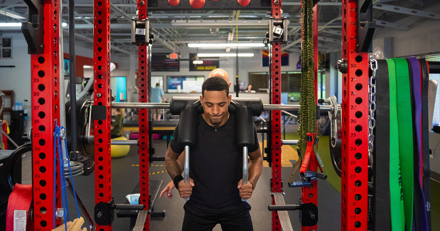 A man using a squat rack at Spooner Uptown Chandler.