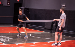 Adam Loiacono with an assistant doing a demonstration on a basketball court.