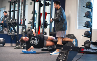 Parker Hirsch, PT, DPT, FAS with a female patient as she does a later plank.