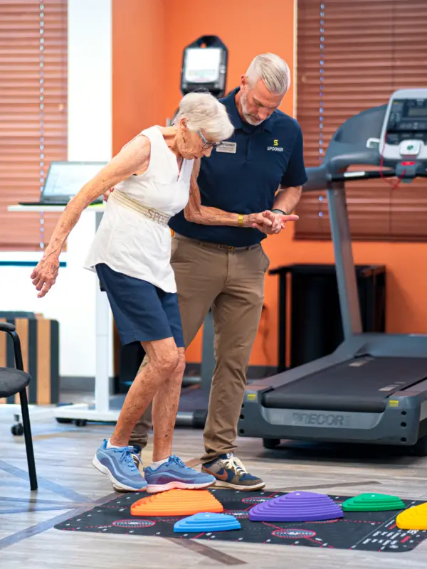 Arron Reinhardt body image Aaron Reinhardt helping an older woman balance on rubber pads.