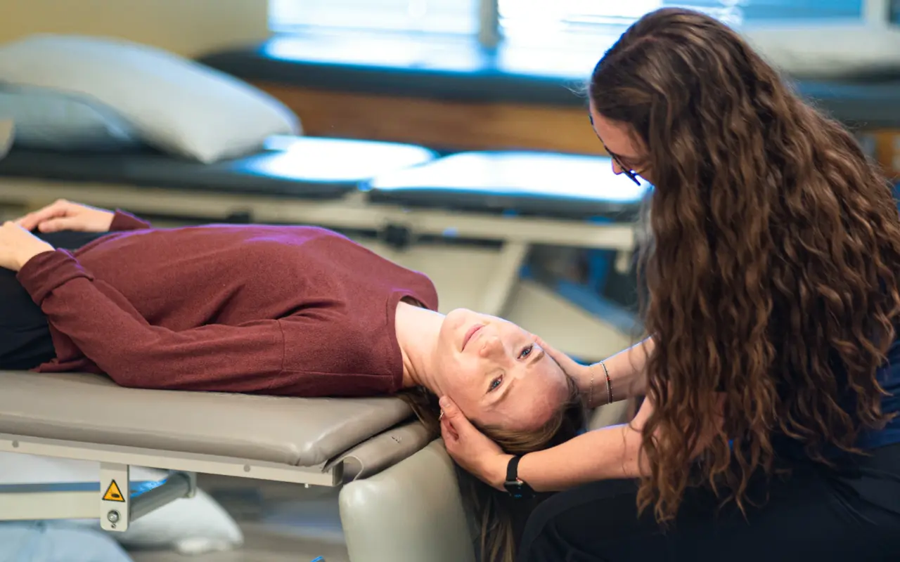 A woman laying on a table as she gets treated for vertigo.