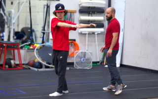 Tanner Chitwood with a male athlete as he does standing twists.