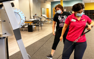 Physical therapist giving demonstration to breast cancer patient