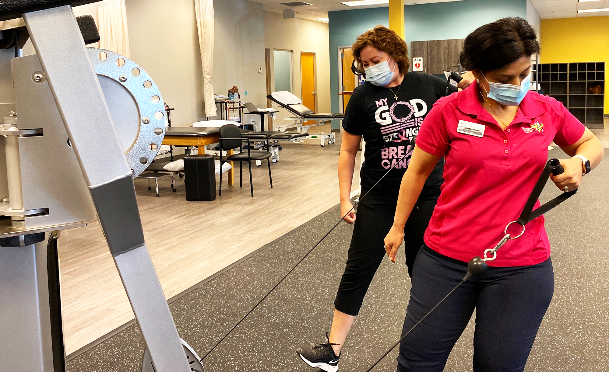 Physical therapist giving demonstration to breast cancer patient