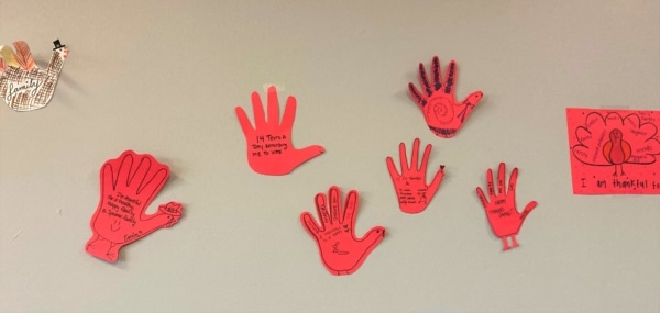 Paper hands on a wall.