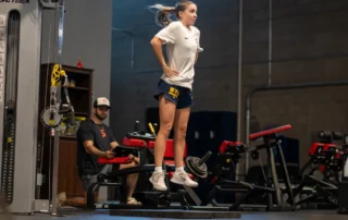 A young female athlete using a vald force plate to test her jump performance.