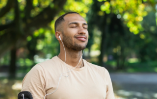 Feature image of a man listening to music outside.