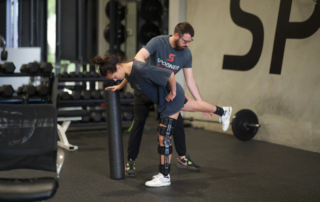 A physical therapist rehabilitating a female athlete after knee surgery.