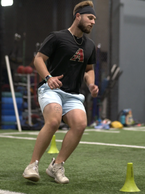 A Diamondbacks player running around cones.