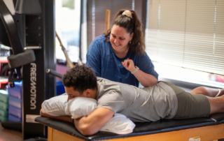 A physical therapist performing pelvic floor manipulation on a male athlete.