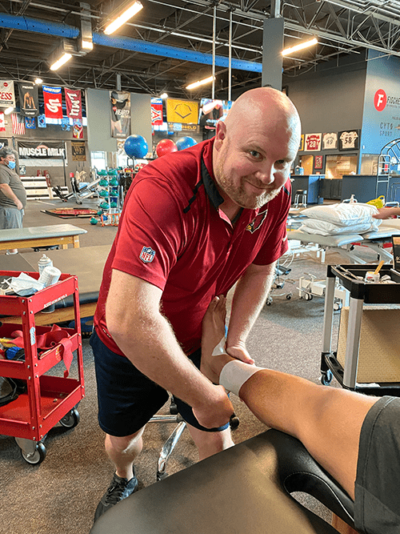 Nick Thomas wraps an athlete's ankle with bandage