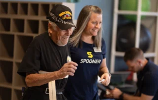 An older man getting helped by a physical therapist.