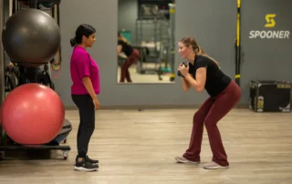 A postpartum woman in physical therapy doing exercises with her therapist.