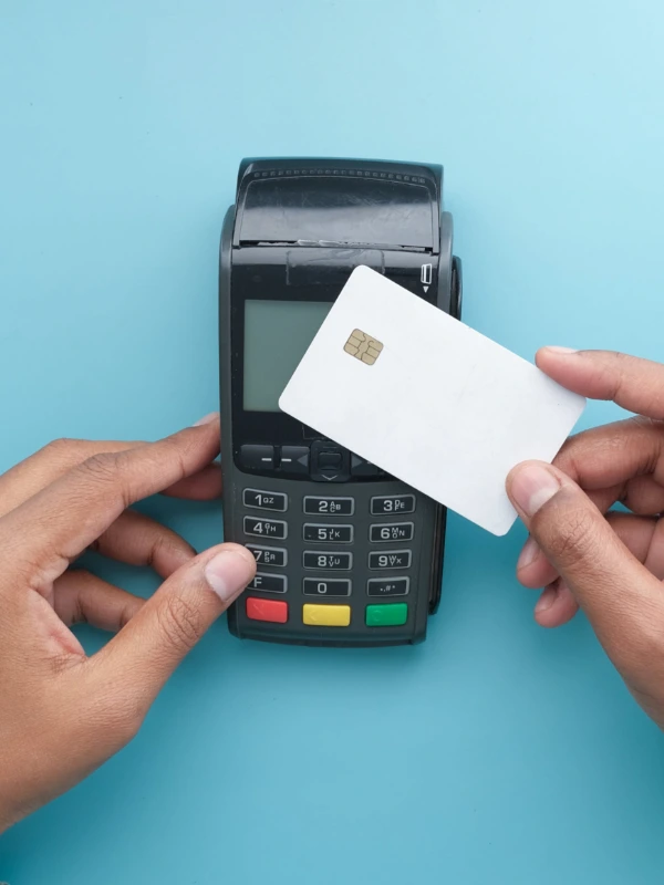 A blank credit card and a payment machine on a blue background.