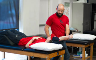 Man receives shoulder manipulation form a physical therapist.