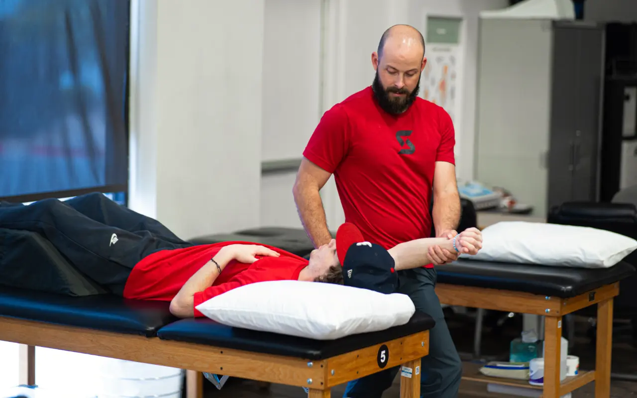 Man receives shoulder manipulation form a physical therapist.