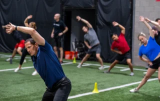 Torrey Foster and a group of athletes doing overhead stretches to help with shoulder impingement.