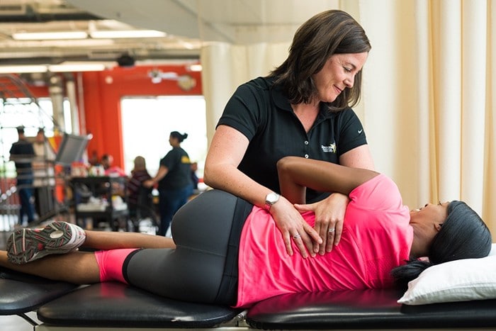 A physical therapist doing spine manipulation on a patient.