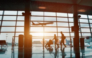 A family in an airport as a plane takes off outside.