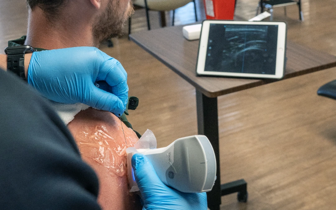 Feature image of a man having ultrasound dry needling done on his shoulder.